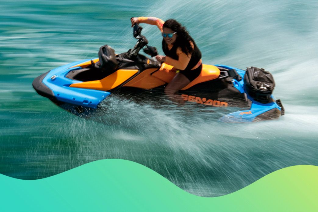 A person in swimwear navigates a bright blue and orange jet ski through shimmering turquoise water, creating splashes as they speed across the surface under sunlight, featured in the Soundtrack to Summer Sweepstakes