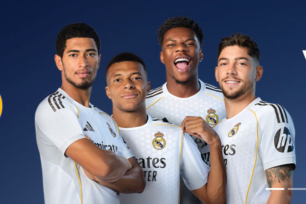Four soccer players stand together, wearing white jerseys, smiling and posing for the camera. Their enthusiastic expressions convey team spirit and camaraderie, featured in the NIVEA MEN Madrid Experience Sweepstakes