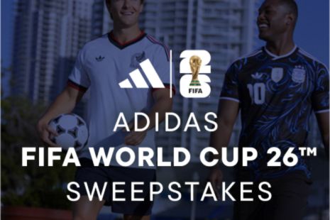 Two young men walk outdoors, one holding a soccer ball, both wearing soccer jerseys, promoting an upcoming FIFA World Cup event, featured in the adidas x Champs Sports World Cup Sweepstakes