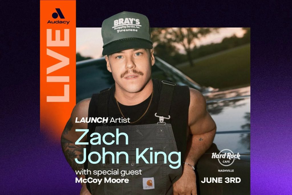 A man with a mustache wearing a cap and overalls leans against a car, promoting a live music event featuring Zach John King and McCoy Moore. The scene has a warm, outdoor ambiance, featured in the Zach John King Flyaway