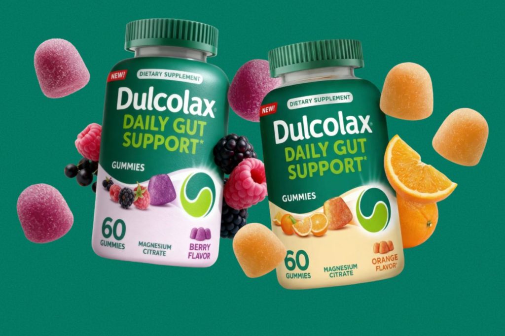 Two containers of gummy supplements are shown, one berry and one orange flavor, surrounded by colorful fruit. They are designed to support gut health with magnesium citrate, featured in the Dulcolax Daily Gut Support Gummies Sweepstakes