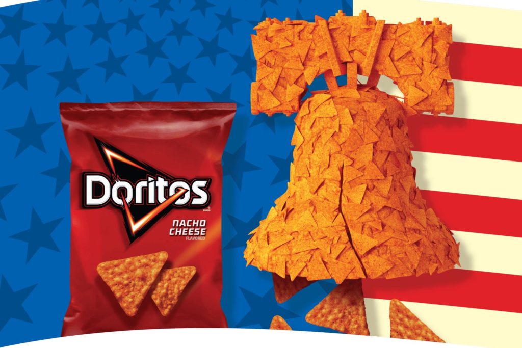 A bell made of nacho cheese chips stands against a red, white, and blue background, with a Doritos bag and chips nearby, creating a festive snack-themed scene, featured in the Doritos $250,000 Sweepstakes