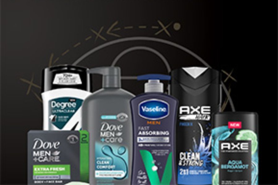 A variety of men's grooming products are displayed, including body wash, lotion, and deodorant, arranged in a visually appealing manner against a dark background, featured in the Unilever Smart TV Sweepstakes