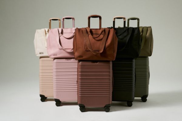 A collection of stylish suitcases and tote bags in various colors, arranged side by side, showcasing modern travel essentials against a neutral background, featured in the BEIS Luggage and $10K Travel Card Sweepstakes
