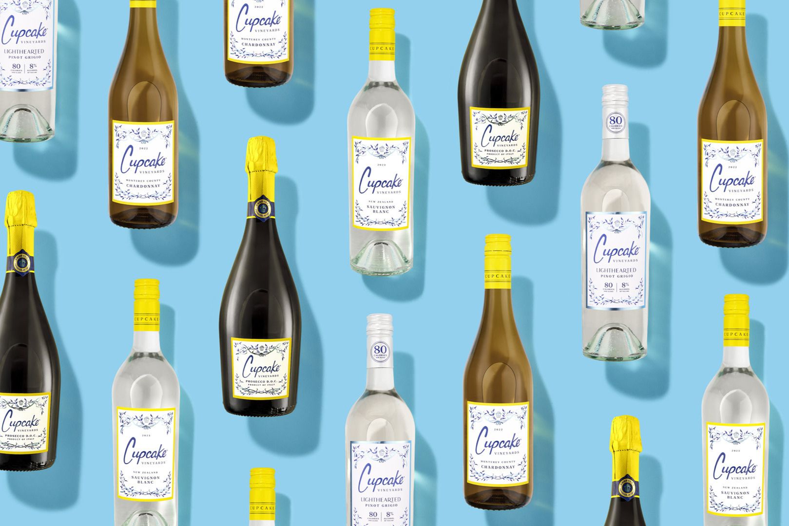 A vibrant arrangement of various bottles of wine against a light blue background, showcasing different types, including Chardonnay, Sauvignon Blanc, and Prosecco, featured in the Cupcake Vineyards Win Your Summer Sweepstakes