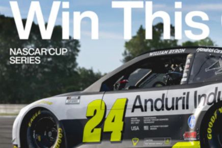 A NASCAR race car with the number 24, featuring a sleek design and sponsor branding, speeds along a track with green trees in the background, showcasing thrilling motorsport action, featured in the Anduril NASCAR Race Experience Sweepstakes